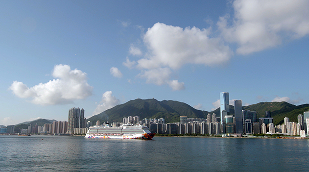 香港の街をバックに入港するワールド ドリーム